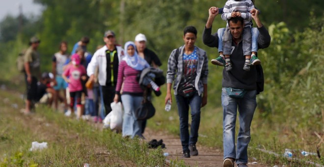 Refugiados sirios caminan por unas vías de tren tras cruzar la frontera que separa a Hungría de Serbia. REUTERS