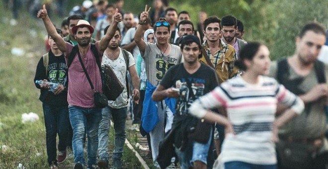 Migrantes son vistos en un cruce ferroviario en la frontera entre Hungría y Serbia cerca a Roszke (Hungría). Mientras la Unión Europea intenta negociar con la cantidad de personas que cruan el mar mediterráneo principalmente a Italia y Grecia, muchos esco