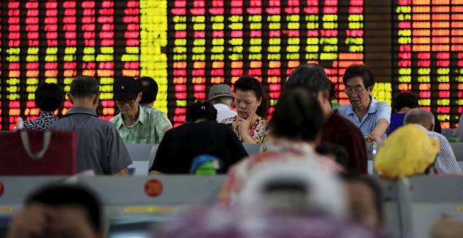 Varios inversores consultan la marcha de las bolsas en los ordenadores de una firma de brokers en Shanghai (China).. REUTERS/Aly Song