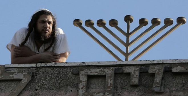 Un colono judío en la azotea de una antigua casa de una familia palestina en Jerusalén Este. - AFP
