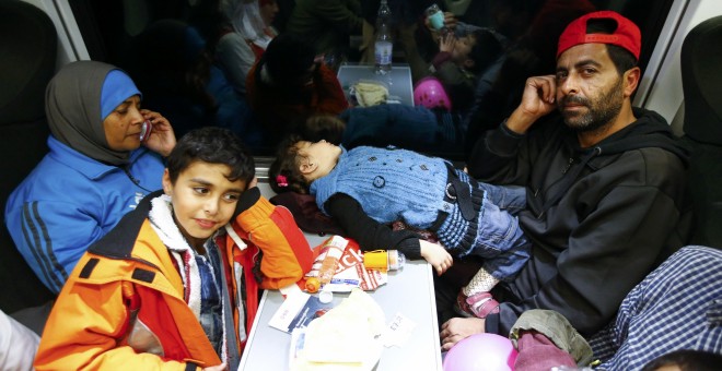 Una famiia de emigrantes a bordo de un tren a punto de llegar a Viena. /REUTERS