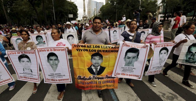 Manifestantes con las fotos de los 43 estudiantes desaparecidos en Iguala, México. REUTERS