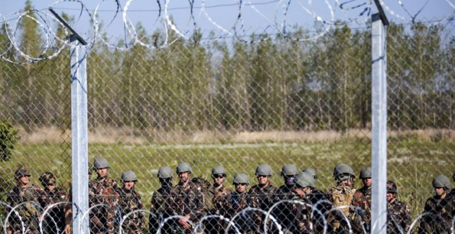 Soldados húngaros hacen guardia en Rozke, en la frontera con Serbia. / EFE