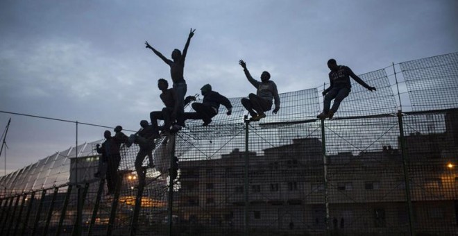 Santiago Palacios por la imagen 'La valla', donde se ve a un grupo de inmigrantes subsaharianos que piden amparo encaramados en la alambrada fronteriza de Melilla.