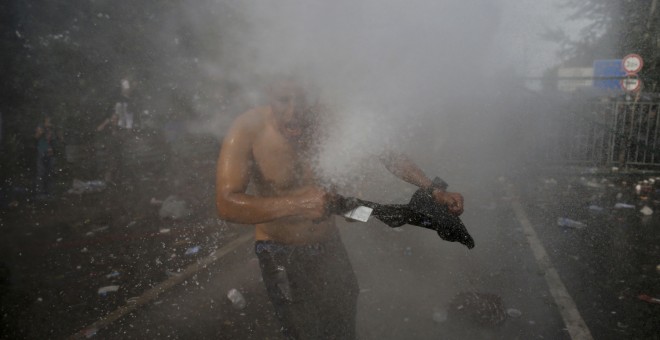 Un migrante es golpeado por un chorro del cañón de agua utilizado por la policía antidisturbios húngara en la parte serbia de la frontera, cerca de Röszke. REUTERS