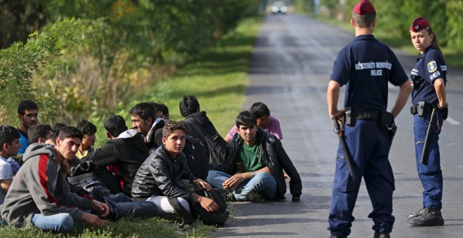 Policías húngaros con inmigrantes afganos cerca de la frontera con Serbia. REUTERS/Dado Ruvic