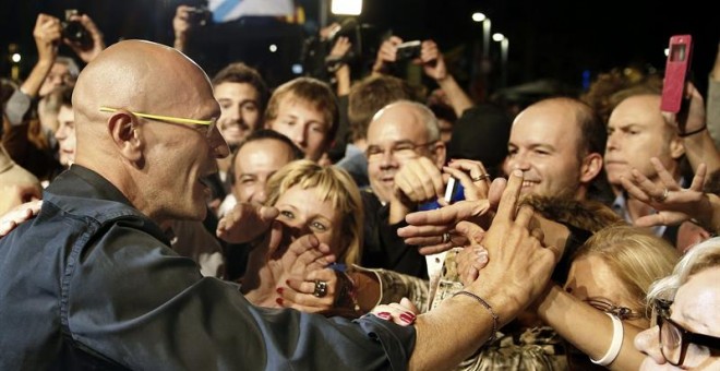 El cabeza de lista de Junts pel Si, Raul Romeva, saluda a los simpatizantes de su formación que esperan los resultados de las elecciones catalanas frente al cuartel general ubicado frente al Mercat del Born./ EFE