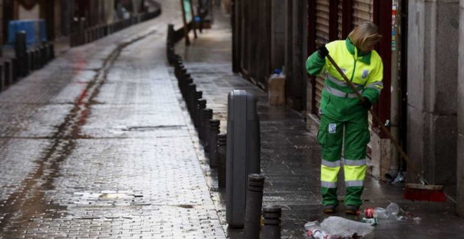 Una trabajadora de los Servicios de Limpieza de Madrid recoge basura. EFE