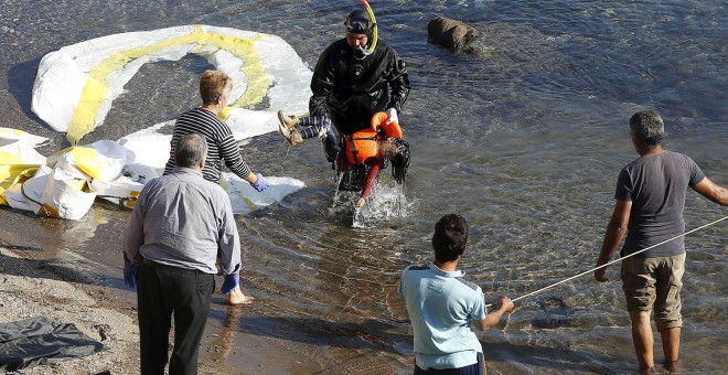 Un guardacostas griego saca del agua el cadáver de un niño refugiado en la costa griega de Lesbos. REUTERS/GIORGOS MOUTAFIS