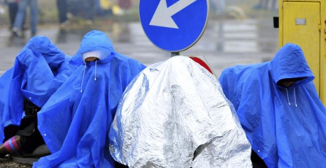 Refugiados esperan bajo la lluvia en la frontera entre Croacia y Eslovenia en Trnovec. - EFE