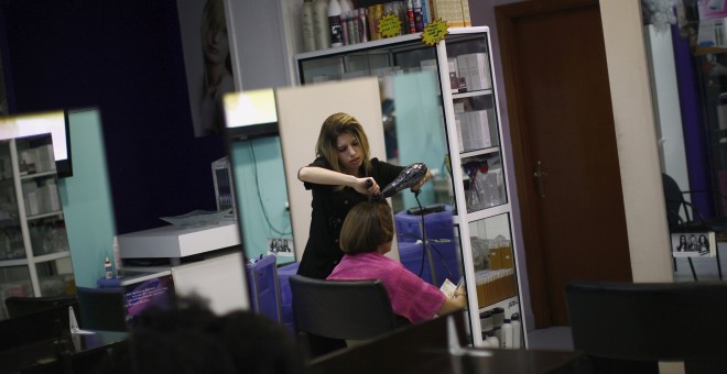 Una peluquera atiende a una clienta en un local de Ronda, Málaga. /REUTERS