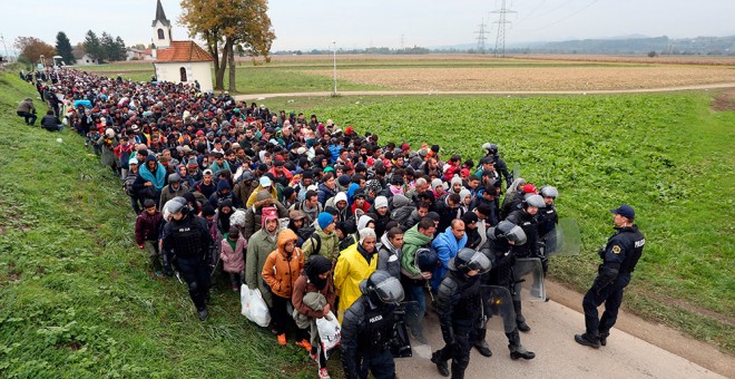 Un millar de inmigrantes son escoltados por policías eslovenos desde el cruce de la frontera con Croacia.- AFP