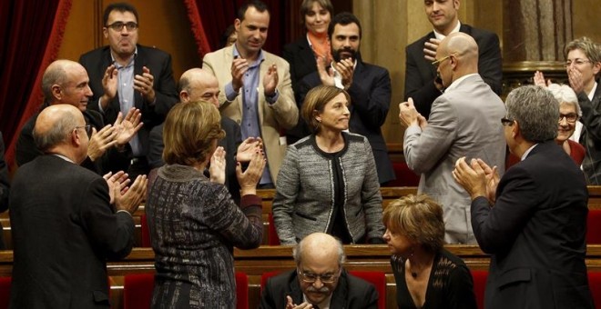 Diputados de Junts pel Sí y miembros del Govern en funciones, aplauden a la número dos de la candidatura de Junts pel Sí, Carme Forcadell, que ha sido elegida hoy nueva presidenta, con 77 votos a favor, el 57 % de la Cámara./ EFE