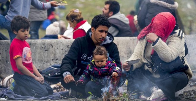 Una familia de refugiados aguarda en la frontera entre Austria y Eslovenia en la ciudad Spielfeld, en la región de Estiria (Austria). EFE/Erwin Scheriau