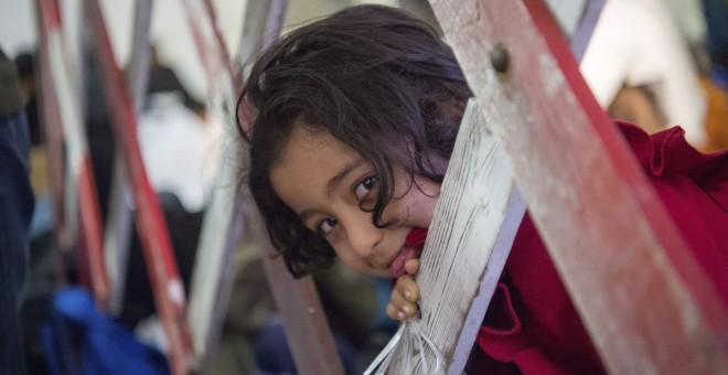 Una niña afgana sonríe en Hanging (Austria) hoy, 3 de noviembre de 2015, antes de cruzar la frontera hacia Alemania. El Instituto de Estudios Económicos de Berlín (DIW) considera que en un plazo de 5 a 7 años los refugiados empezarán a contribuir al biene