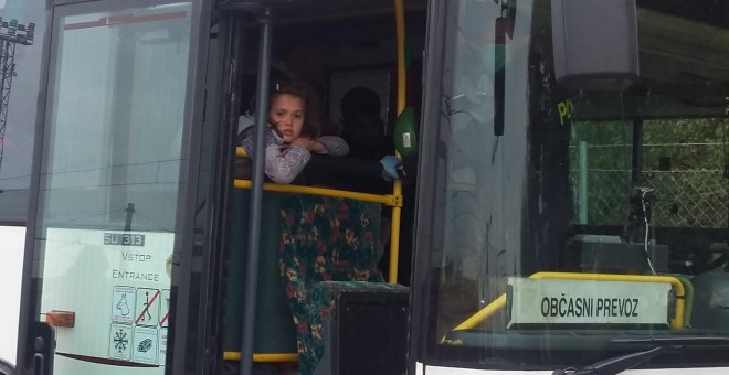 Una pequeña aguarda a que arranque el bus que le permitirá frontar cruzar la frontera.