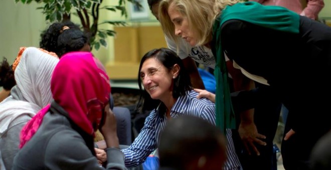 Fotografía facilitada por Presidencia del Gobierno de la secretaria general de Inmigración y Emigración, Marina del Corral (d), conversando con el grupo de solicitantes de asilo compuesto por cuatro mujeres y ocho hombres llegados anoche. /EFE