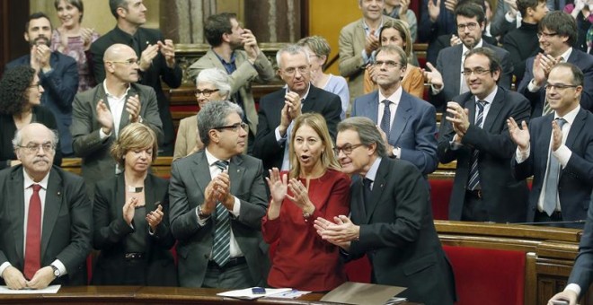 El presidente de la Generalitat en funciones, junto a miembros de su gobierno y diputados de Junts pel Si, aplaude tras aprobarse en el Parlament de Catalunya la resolución conjunta de Junts pel Sí y la CUP./ EFE