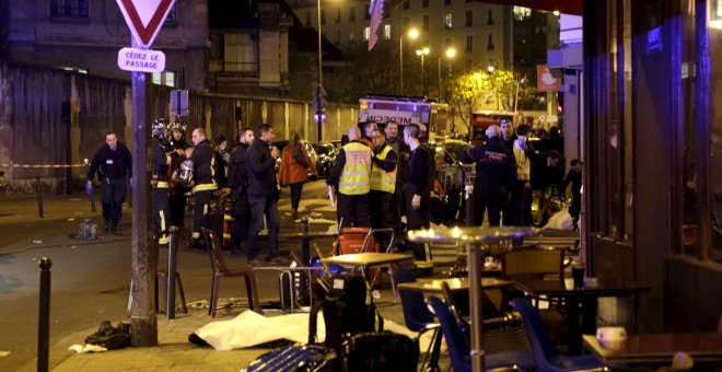Los servicios de rescate cerca de los cuerpos cubiertos fuera de un restaurante Tras un tiroteo en París, Francia, 13 de noviembre de 2015. REUTERS / Philippe WOJAZER