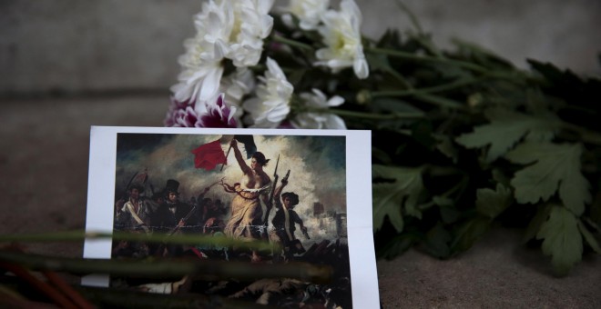 Icónica imagen de un ramo de flores junto a una fotografía del cuadro La Libertad guiando al pueblo.