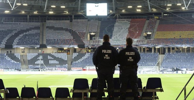 17/11/2015. Dos agentes de la policía permanecen en las gradas antes del partido amistoso entre Alemania y Holanda en el IDH-Arena en Hannover (Alemania) hoy, 17 de noviembre de 2015. El IDH Arena ha sido evacuado por 'razones de seguridad' y el partido h
