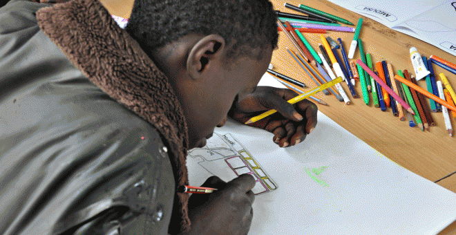 Un niño de la calle dibuja un matatu o furgoneta para viajeros en un taller de dibujo en Nairobi. EFE