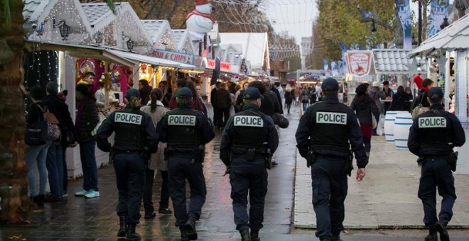 Miembros de la policía patrullan un mercado navideño en la Avenida Campos Elíseos en París, el pasado jueves./ EFE