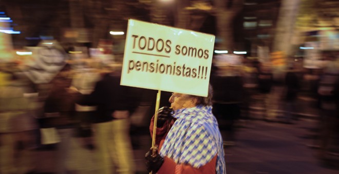 Una anciana con una pancarta que dice 'Todos somos pensionistas', en una manifestación contra las medidas del Gobierno. AFP / Pedro Armeste