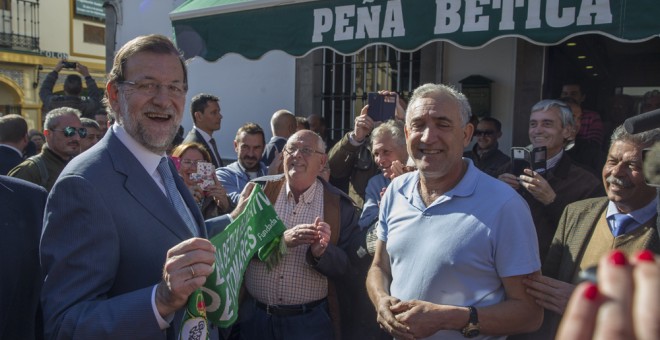 El jefe del Ejecutivo, Mariano Rajoy, es obsequiado con una bufanda del Real Betis en un peña futbolística, en su reciente visita a Sevilla. EFE/Julio Muñoz