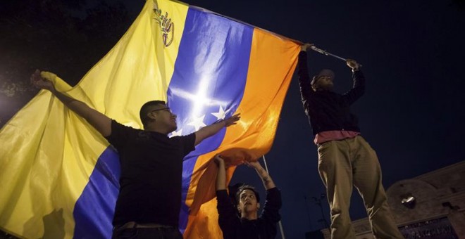 Un grupo de personas celebra la victoria obtenida por la coalición opositora Mesa de Unidad Democrática (MUD)  este lunes en Caracas./ EFE