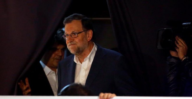 Mariano Rajoy sale al balcón para dirigirse a sus simpatizantes en el exterior de la sede de su partido en la calle Génova en la noche electoral. / CHEMA MOYA (EFE)