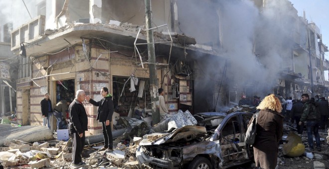 Policías sirios inspeccionan el lugar donde se ha producido un atentado en una zona residencial en Homs.- EFE