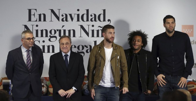 El consejero de Políticas Sociales y Familia, Carlos Izquierdo, el presidente del Real Madrid, Florentino Pérez, y los jugadores de la primera plantilla de fútbol y baloncesto, Sergio Ramos, Marcelo y Felipe Reyes, durante la presentación de la campaña 'E