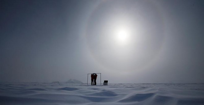 Imagen tomada el 18 de noviembre de 2015 que muestra a dos científicos midiendo la radiación solar y su albedo en el campamento Glaciar Union, a 1000 km del Polo Sur. Investigadores de la Universidad de Santiago de Chile informaron hoy que en los primeros