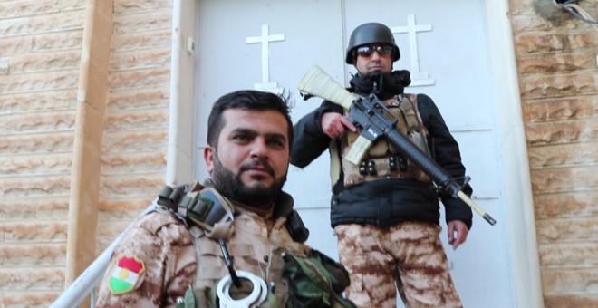 Peshmergas kurdos patrullan la ciudad cristiana de Telskoff, en Iraq. FERRÁN BARBER