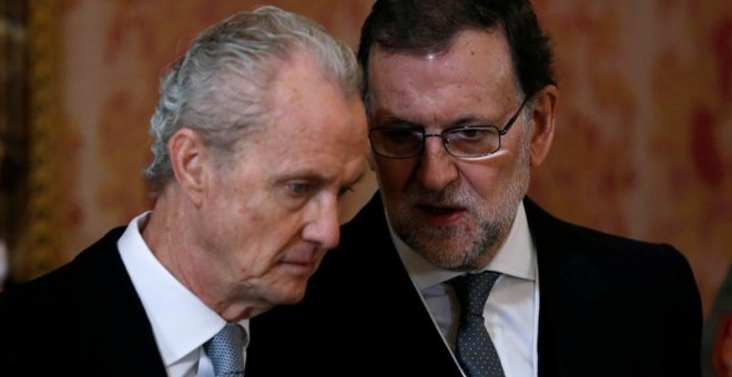 El presidente del Gobierno en funciones, Mariano Rajoy (d), conversa con el ministro de Defensa, Pedro Morenés, durante la celebración de la Pascua Militar que ha presidido hoy el rey Felipe VI, acompañado de doña Letizia, en el Salón del Trono del Palaci