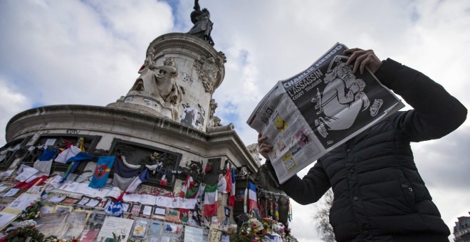 Un hombre ojea el número especial publicado por el semanario satírico 'Charlie Hebdo' con motivo del primer aniversario del atentado yihadista contra su redacción, en la Plaza de la República de París. EFE/Ian Langsdon