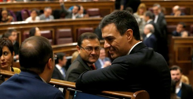 El secretario general del PSOE, Pedro Sánchez, conversa con el diputado socialista César Luena. EFE