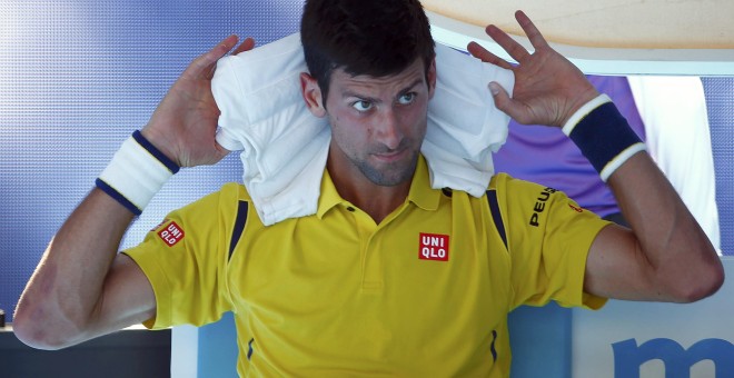 Novak Djokovic, número uno del mundo, se pone una toalla mojada para paliar el calor en su partido contra el coreano Chung en el Open de Australia. /REUTERS