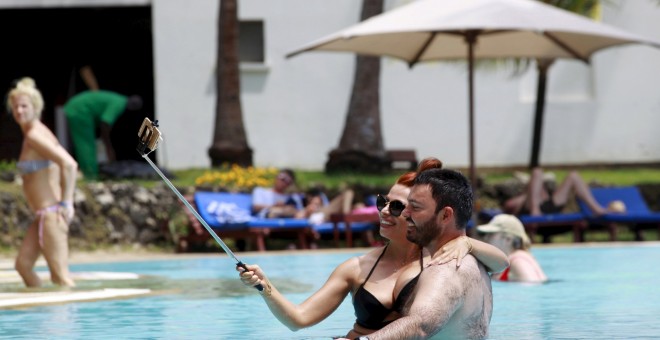 Los turistas toman una fotografía selfie dentro de una piscina en el hotel de playa Voyager en la ciudad costera de Mombasa. REUTERS