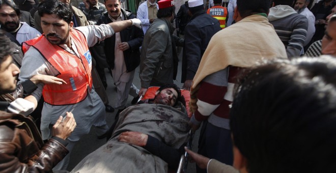 Varias personas trasladan en camilla a una víctima al hospital en Charsadda donde están ingresadas algunas de las víctimas del asalto talibán a la universidad Bacha Khan del norte de Pakistán, en el que han muerto decenas de personas, entre ellas varios e