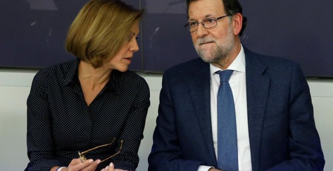 El presidente del Gobierno, Mariano Rajoy, conversa con la secretaria general del PP, María Dolores de Cospedal, durante la reunión de la Junta Directiva Nacional del PP celebrada en la sede del partido en Madrid, para aprobar las propuestas de los candid