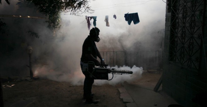 Un hombre fumiga el vecindario de Altos del Cerro, en Salvador, contra el virus del Zika. REUTERS