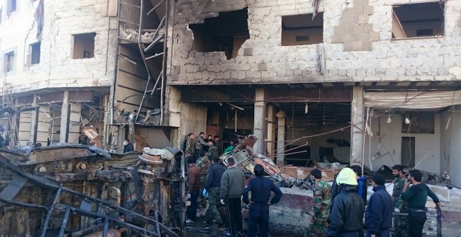 Residentes y soldados leales al presidente sirio Bashar al-Assad inspecionan la zona de los atentados yihadistas en el barrio chií de SDamasco. REUTERS/Stringer