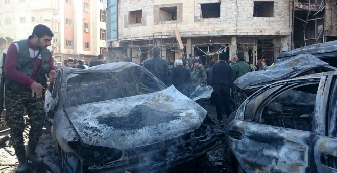 Residentes y soldados leales al presidente sirio Bashar al-Assad inspecionan la zona de los atentados yihadistas en el barrio chií de Damasco. REUTERS/Stringer