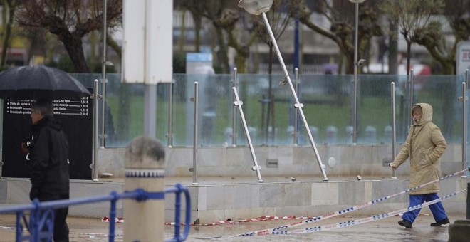 Una persona camina esta mañana por el paseo de la playa del Sardinero, afectado por el temporal marítimo de ayer. EFE