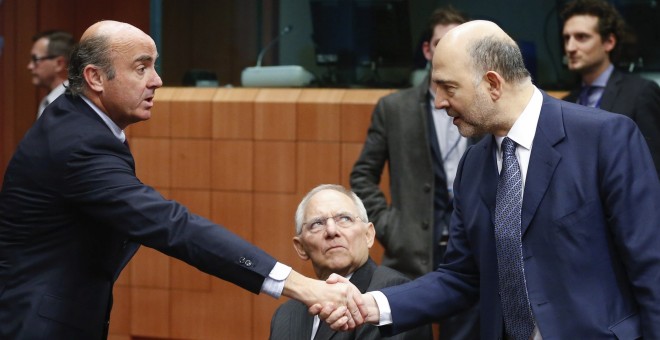El ministro español de Economía en funciones, Luis de Guindos, saluda al comisario europeo de Asuntos Económicos y Financieros, Pierre Moscovici, en presencia del ministro alemán de Finanzas, Wolfgang Schaeuble. EFE/LAURENT DUBRULE