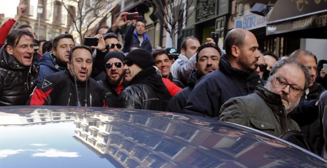 El concejal de Salud, Seguridad y Emergencias de Madrid, Javier Barbero (d), a la salida hoy de las dependencias municipales, se introduce en un coche mientras es increpado por los asistentes a una concentración de policías municipales, en los alrededores