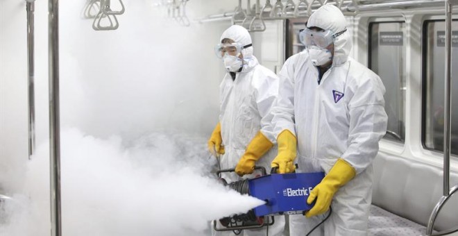 Trabajadores fumigan un vagón de tren en el depósito de trenes en Seúl como prevención ante el virus zika. - EFE