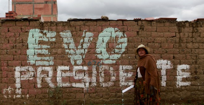 Una mujer camina frente a una pintada en apoyo a Evo Morales en las afueras de La Paz. REUTERS/David Mercado